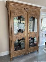 Front view of solid wood beveled glass armoire