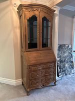 Front view of walnut secretary desk with glass hutch