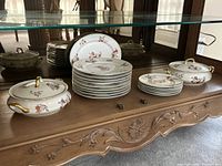 Entire dinnerware set inside cabinet showing tureens, stacked dinner and salad plates, platter in rear