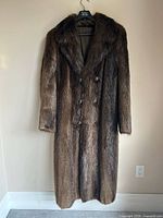 Full view of beaver fur coat hanging, showing length and overall condition