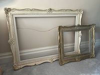 Both ornate wooden frames side by side to show size difference and overall design