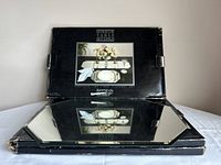 Front view of Kemp & Beatley boxes and one mirrored placemat