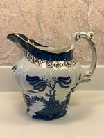 Left side view showing blue willow pattern and gold trimmed rim