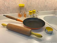 Group view of frying pan, rolling pin, ashtray, juice pitcher, shakers