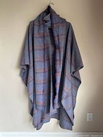 Full view of cape and scarf hanging on wall