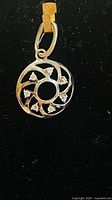 front view of circular sterling silver pendant with stones