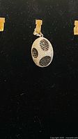 Front view of sterling silver oval pendant with black and clear crystals