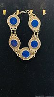 Front view showing five blue lapis cabochons in gold-tone settings