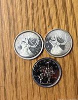 Obverse sides of three Canadian quarters dated 1965, 1966, 1973