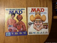 Front covers of both MAD magazines showing boxing spoof and Dallas spoof