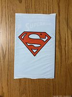 Front of sealed polybag showing Superman shield logo
