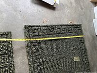 Close-up of mat corner with tape measure showing width