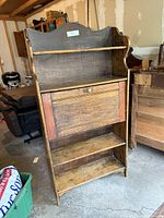Full frontal view of secretary desk showing drop-front closed and two lower shelves
