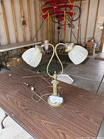 Full view of brass double-arm table lamp on table