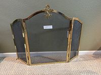 Front view of brass three-panel fireplace screen