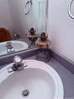 Hurricane lamp on countertop beside sink