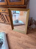 Front view of rectangular mirror leaning against cabinet