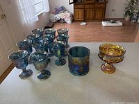 Group of blue goblets with tumbler and marigold compote on countertop