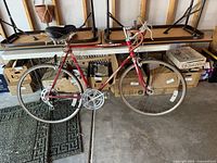 Full side view of red Schwinn Varsity bicycle leaned against tables