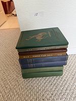 Stack of six hardcover guidebooks showing spines for WGA Jackson Hole 1956 and Powder River Basin 1958 plus additional volumes