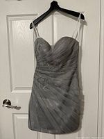 Front view of silver/grey beaded dress on hanger