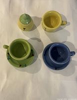 Top view of all seven ceramic pieces showing colors and floral motif