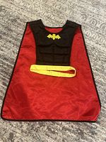 Front view of cape folded to show colour contrast and yellow trim