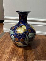Front view of cobalt blue porcelain vase showing floral enamel and gilding
