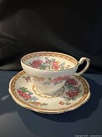 teacup resting on saucer showing floral design and gilt trim