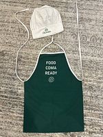 Apron and hat laid flat showing full design and text