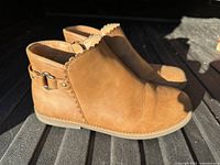 Side view of both ankle boots highlighting color, scalloped edge, buckle detail