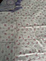 Folded pillowcase and spread-out sheets showing overall pattern and condition