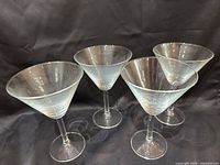 Four clear martini glasses angled view