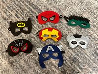 Front view of all seven masks on carpet