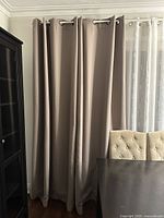 Curtain panels hung on rod beside furniture