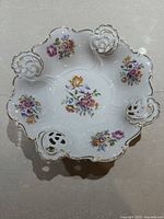 Top view of porcelain bowl showing floral sprays and pierced gilt rim