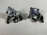 Two Swarovski crystal panda figurines side by side