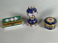 Group shot of three Limoges trinket boxes (rectangular dice, lamp-shaped, round star)
