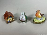 Three Limoges boxes: birdhouse, floral vase, bird on base