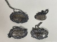 All four sterling silver decanter labels front view