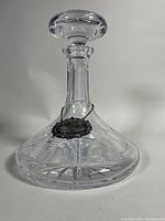 Front view of crystal decanter with stopper and attached silver label