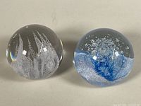 Both paperweights side-by-side showing overall form and scale