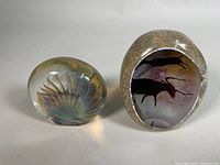 Front view of both paperweights showing designs and relative size