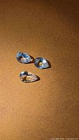 Three pear-cut aquamarines arranged on surface