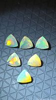 All six trillion-cut opals on dark patterned background