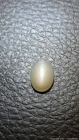 Front view of oval cabochon moonstone showing cat's eye line