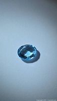 Top view of oval blue topaz showing checkerboard faceting