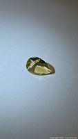 Pear-shaped golden citrine on neutral background, top view