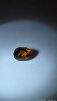 Loose oval golden cognac tourmaline gemstone on white background