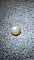 Round light peach moonstone cabochon on textured surface